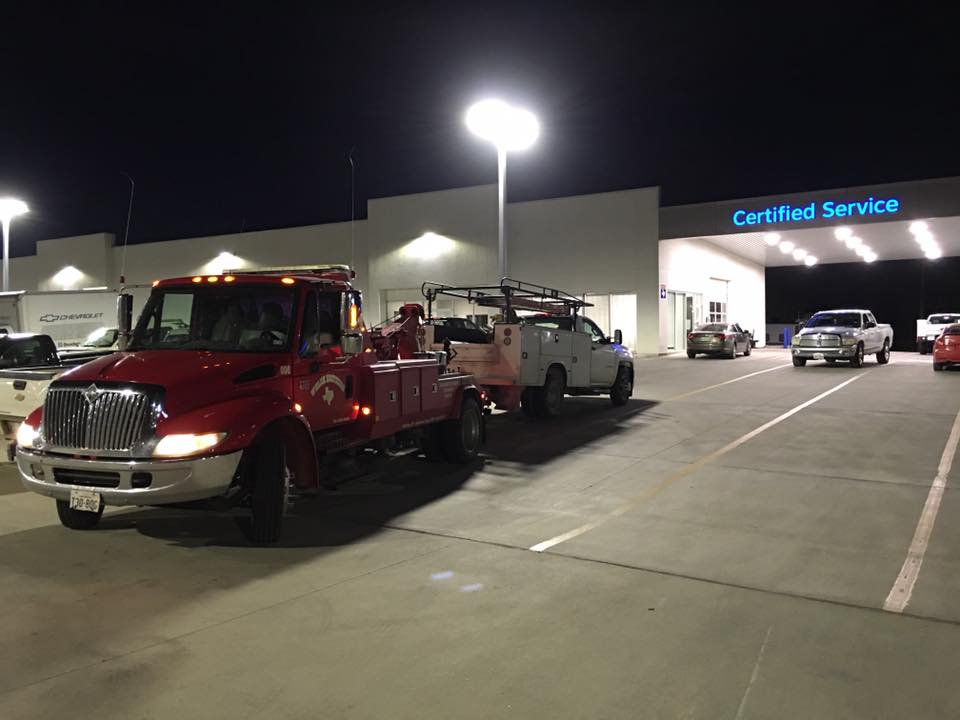 Welch Bros Towing wrecker and service truck responding to a nighttime call at a Brownwood, TX dealership